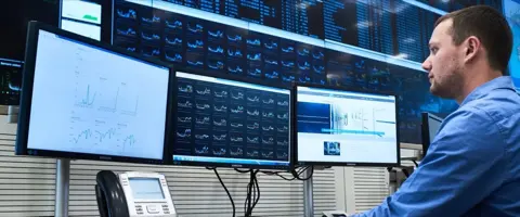 Operatore Host.it davanti ai monitor di monitoraggio nella sala di controllo